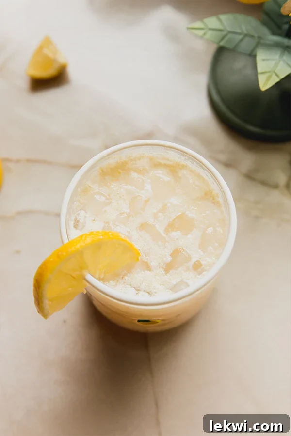 A close-up shot of a glass of Italian Lemon Cream Soda, featuring its creamy texture and fresh lemon slice garnish, set against a soft background.