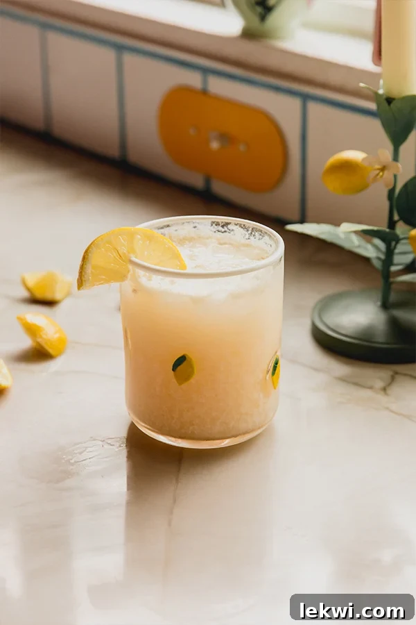 A glass of Italian Lemon Cream Soda with a lemon wedge garnish.