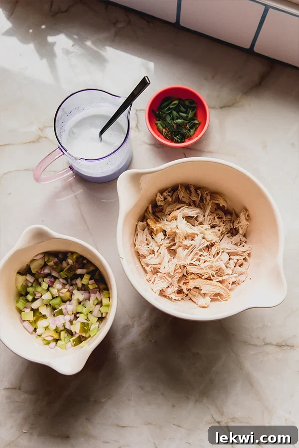 A visual display of all the fresh ingredients laid out on a counter, ready to be combined for the easy dill pickle chicken salad recipe.