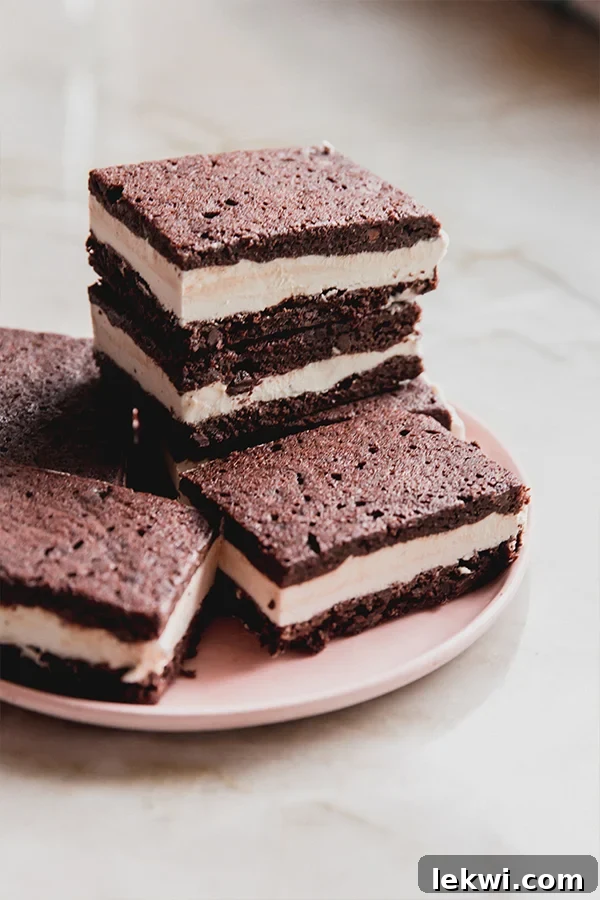 Gluten free brownie ice cream sandwiches stacked on a pink plate.
