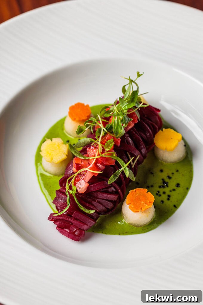 A stunning spiralized beet dish with a vibrant green herb sauce, elegantly topped with fresh herbs, exemplifying the artistry of fine dining at Sérêvène.
