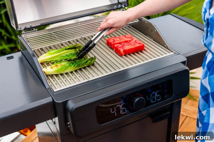 Crisp romaine and juicy watermelon slices being expertly grilled on an electric grill, handled with tongs, highlighting healthy and innovative cooking with Current.