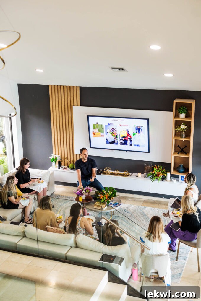 A group of food bloggers sitting comfortably on a spacious couch, intently watching a presentation on a large TV screen during a learning session at the Fresh Air Retreat.