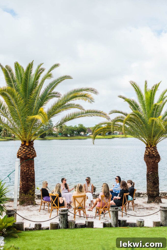 A group of food bloggers engaged in discussion, sitting in a circle on the beach under palm trees, embodying the collaborative spirit of the retreat's learning sessions.