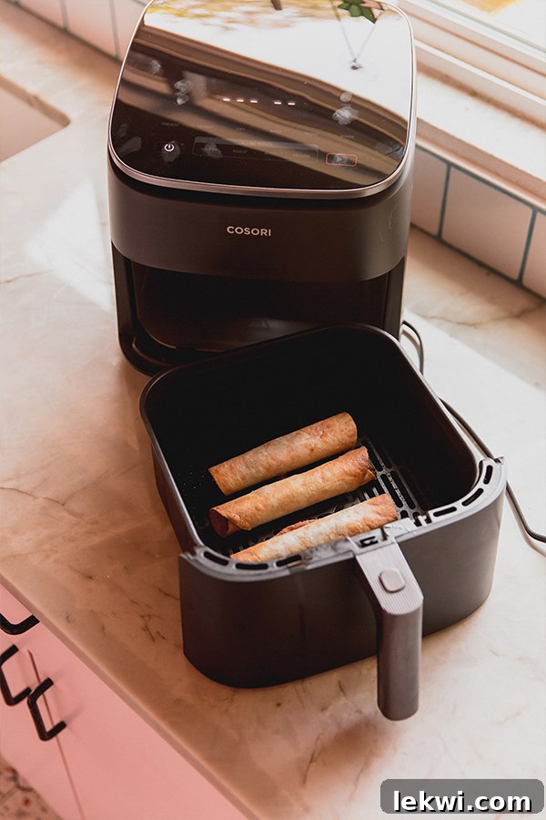 Veggie pizza roll ups in an air fryer basket. 