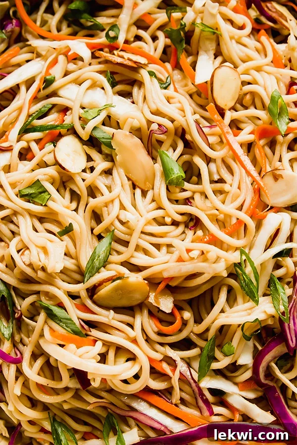Cold ramen noodle salad with ramen and veggies in a large speckled bowl.