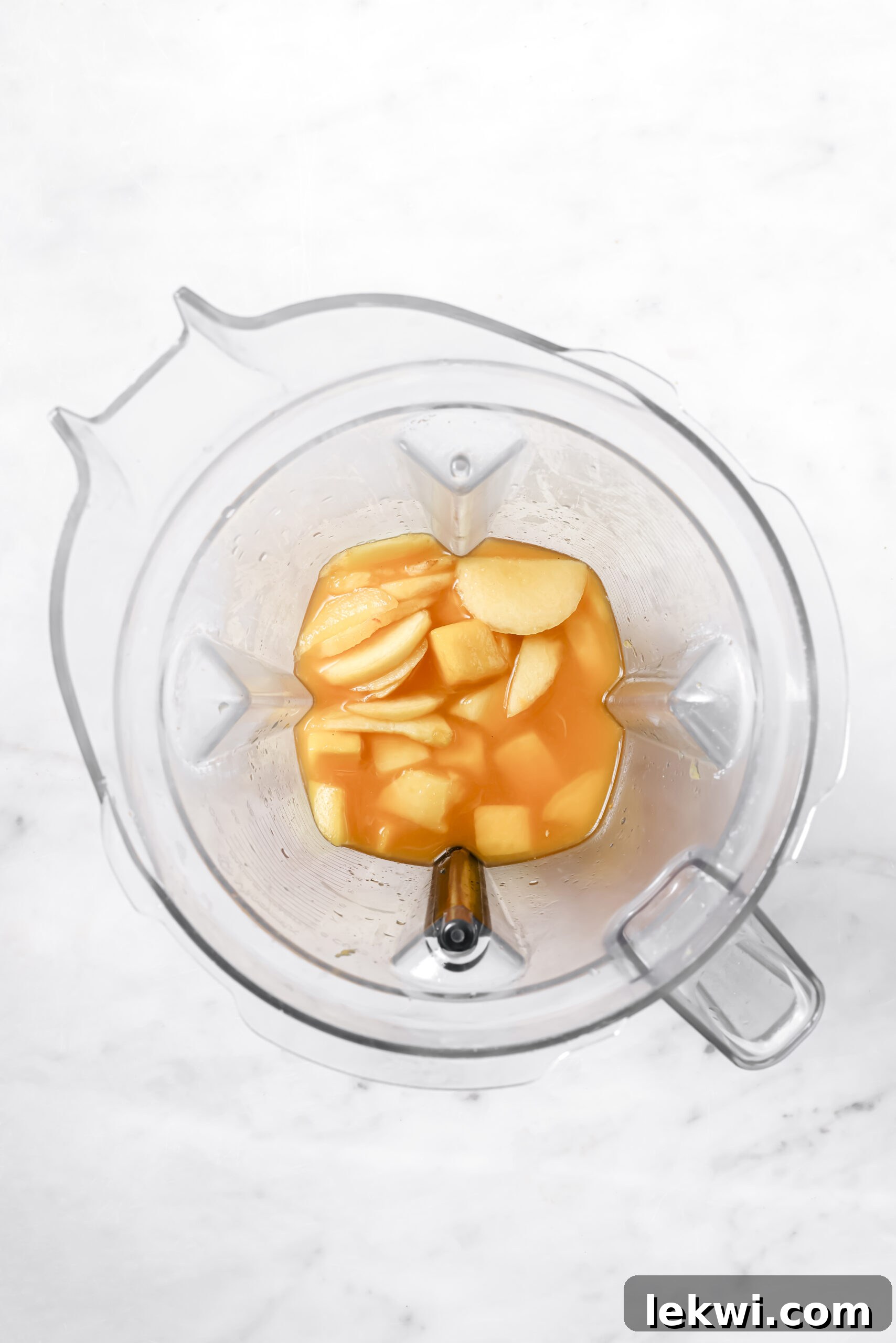 Chopped mango, sliced peaches, and orange juice ready to be blended in a blender for the second flavor.