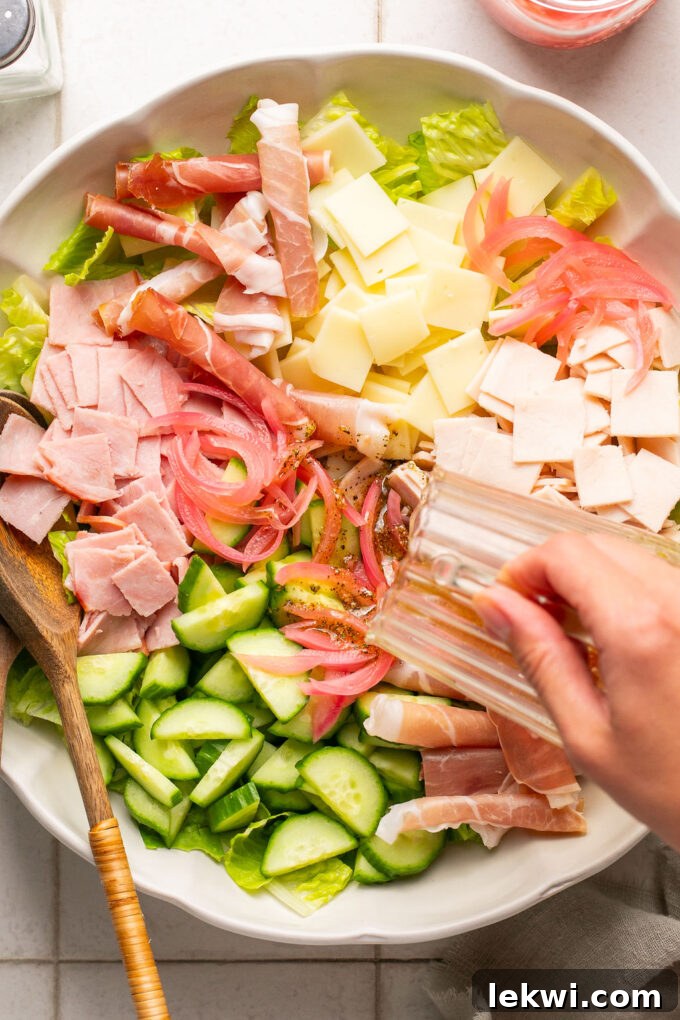 The sub in a tub salad before being mixed, with dressing freshly poured over all the ingredients.