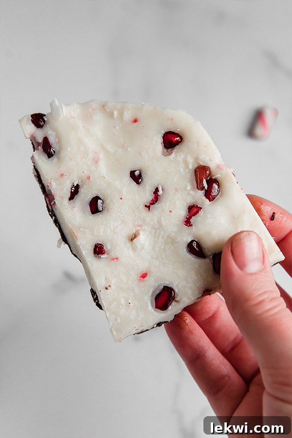 Paleo peppermint bark topped with vibrant red pomegranate seeds, showcasing a beautiful and AIP-friendly holiday dessert.