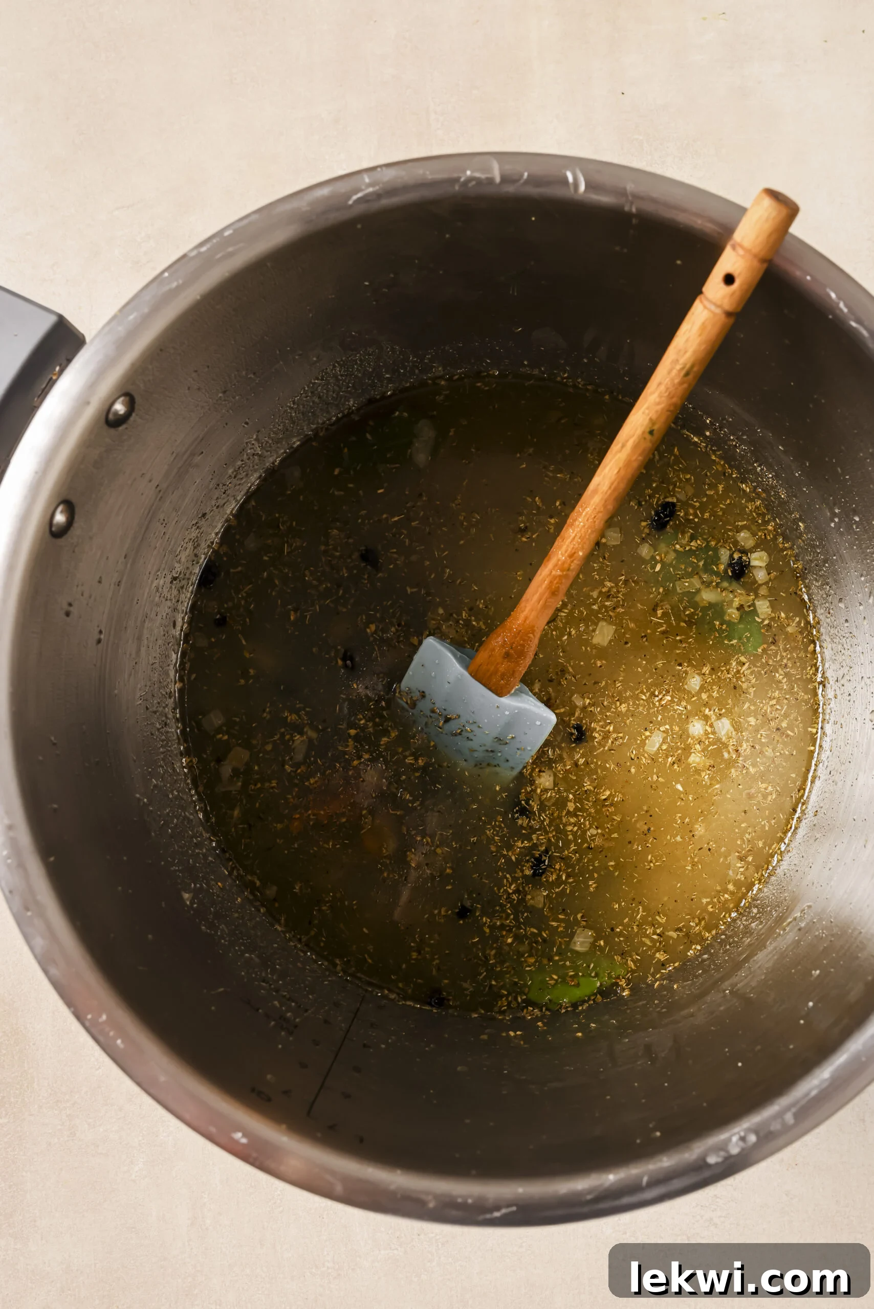 Sautéed onions with broth and herbs in a pressure cooker.