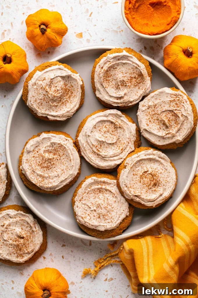 A platter of beautifully frosted pumpkin cookies, each topped with a generous swirl of latte icing, ready to be enjoyed.