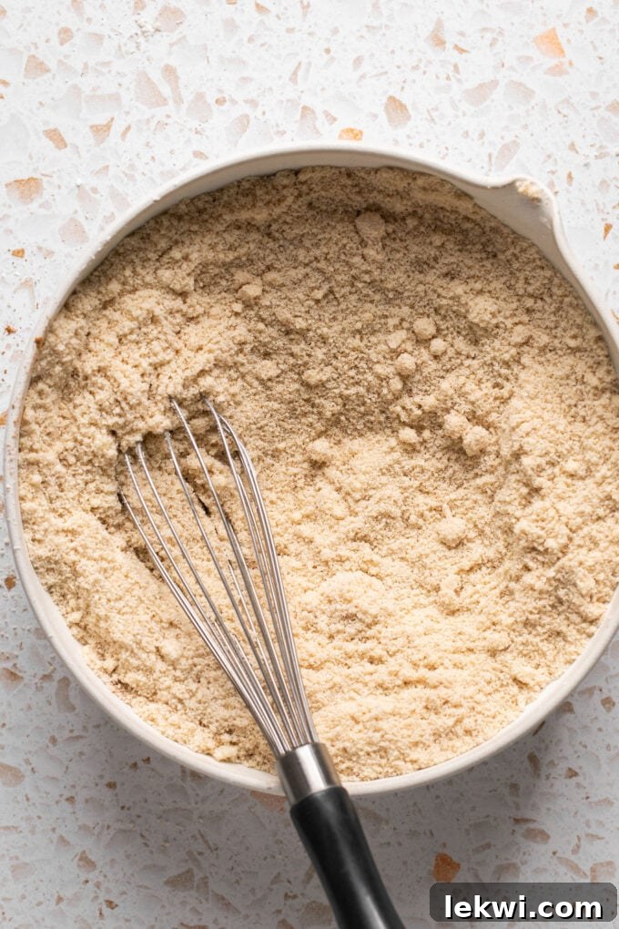 Pumpkin spice cookie dry ingredients in a bowl with a whisk, ready to be mixed.