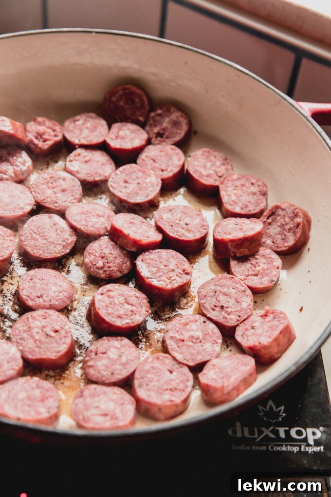Sausage chopped and cooking in a pan.