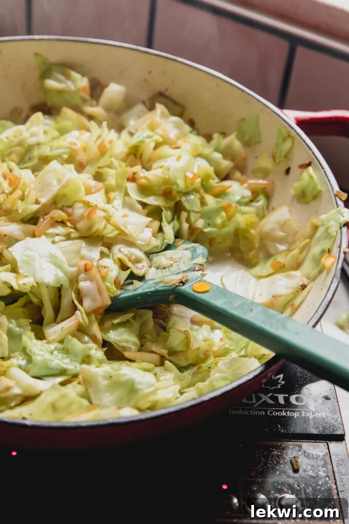 Cooked chopped cabbage being cooked in a large pan.