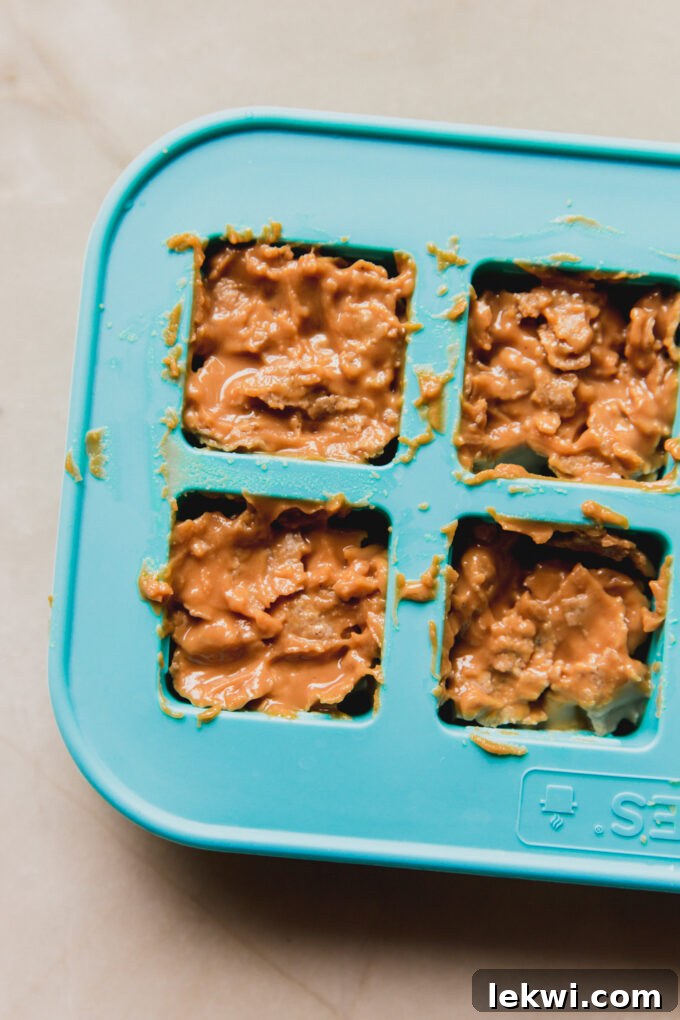 Mini butterfinger copycat filling pressed into a square silicone mold.