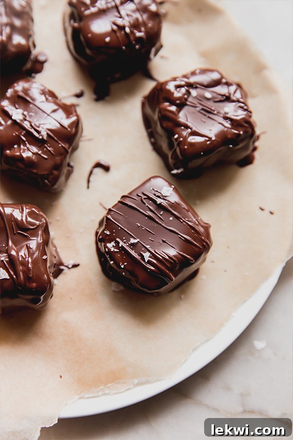Plate of finished mini Snickers bars with flakey salt on top, showcasing the perfect chocolate coating.