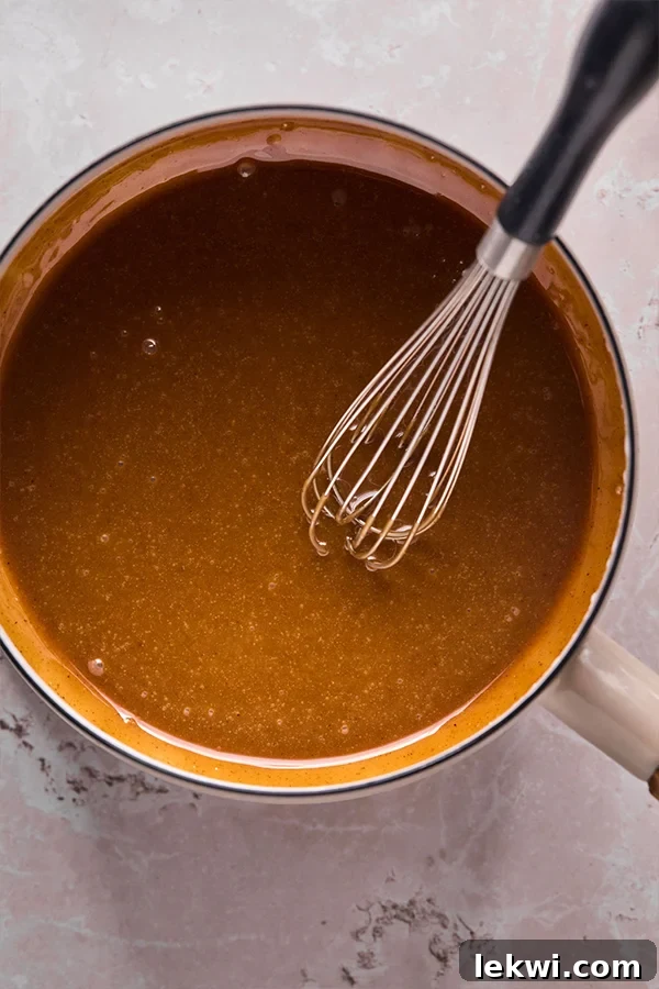 The coconut sugar, coconut oil, and nut butter mixture cooked down to a thick, syrupy consistency in a pot.