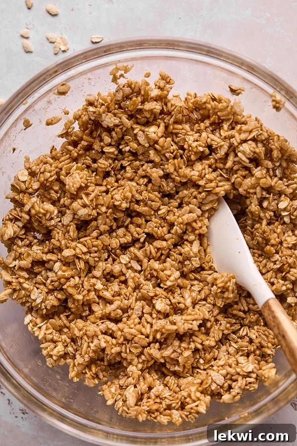 The rice cereal fully incorporated and evenly coated with the almond butter mixture, ready for pressing.