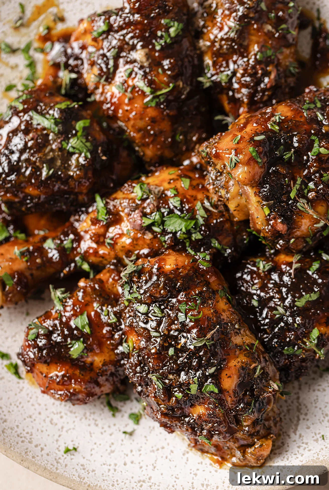 Crispy, glazed turkey wings on a rustic platter, garnished with fresh parsley.