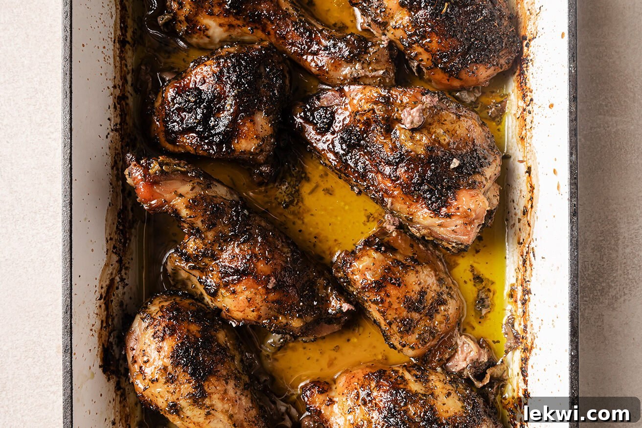 Cooked, golden-brown turkey wings resting in a baking pan, ready for glazing.