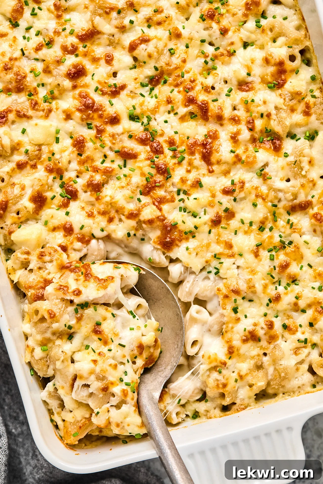 Goat cheese mac and cheese in a casserole dish with a spoon. 