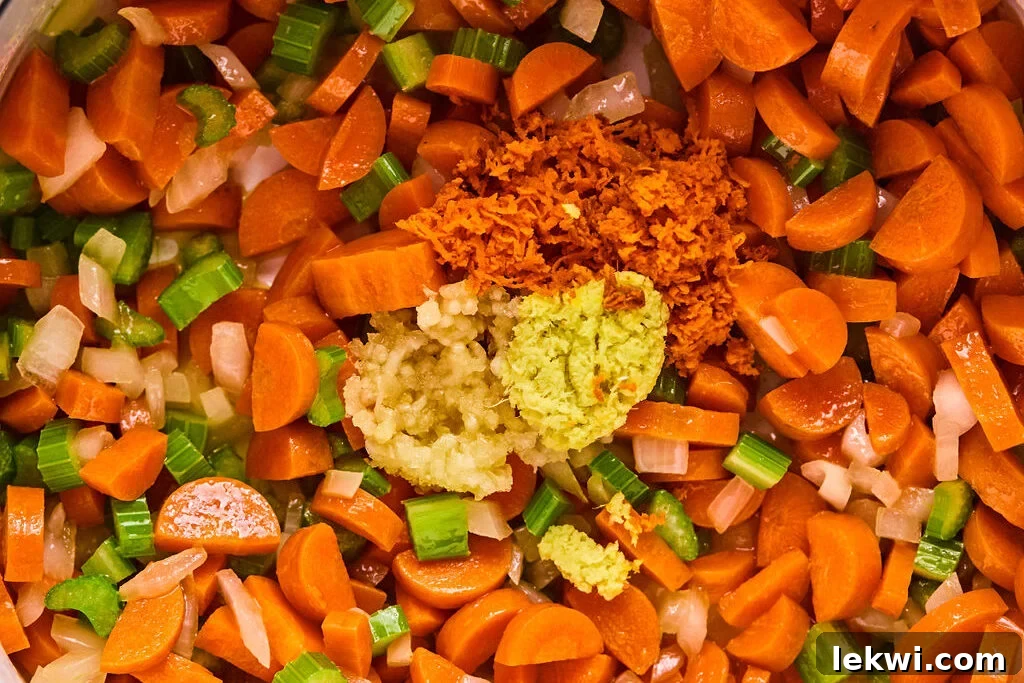 Sautéing the chopped vegetables with fresh garlic, ginger, and turmeric in a pot.