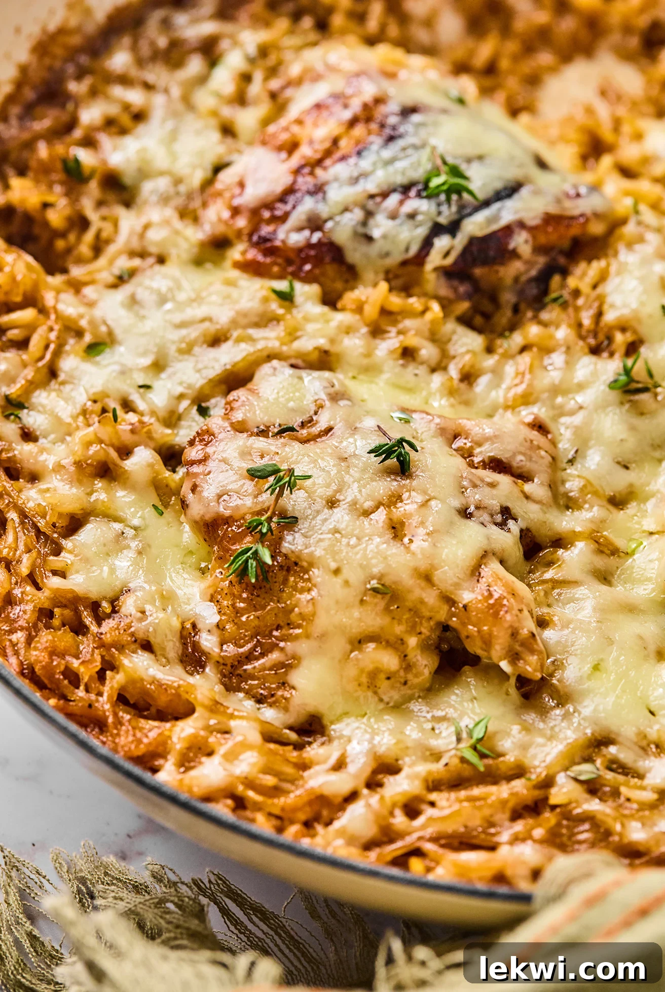 French onion chicken and rice in a large pan topped with thyme, ready to serve.