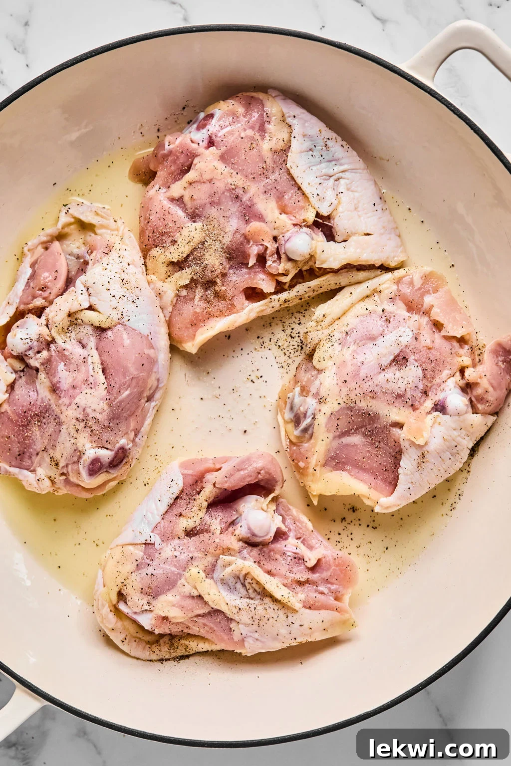 Chicken thighs skin side down in pan, searing to develop a crispy skin.