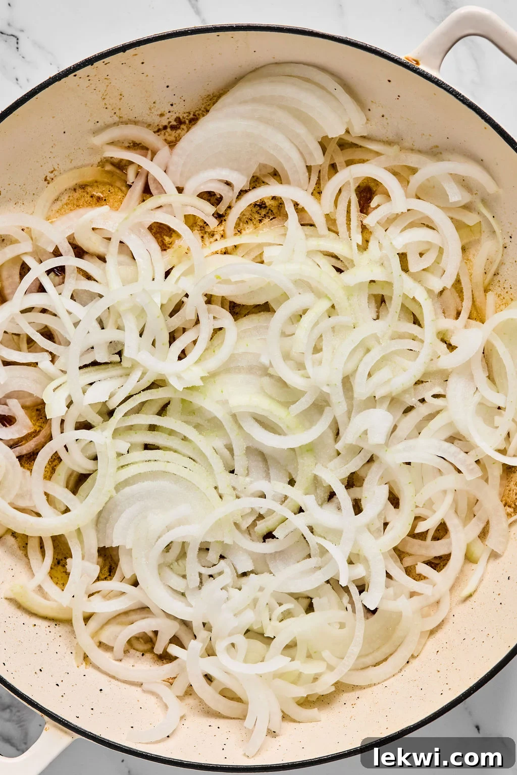 Caramelized onions in a pan with jasmine rice being added.