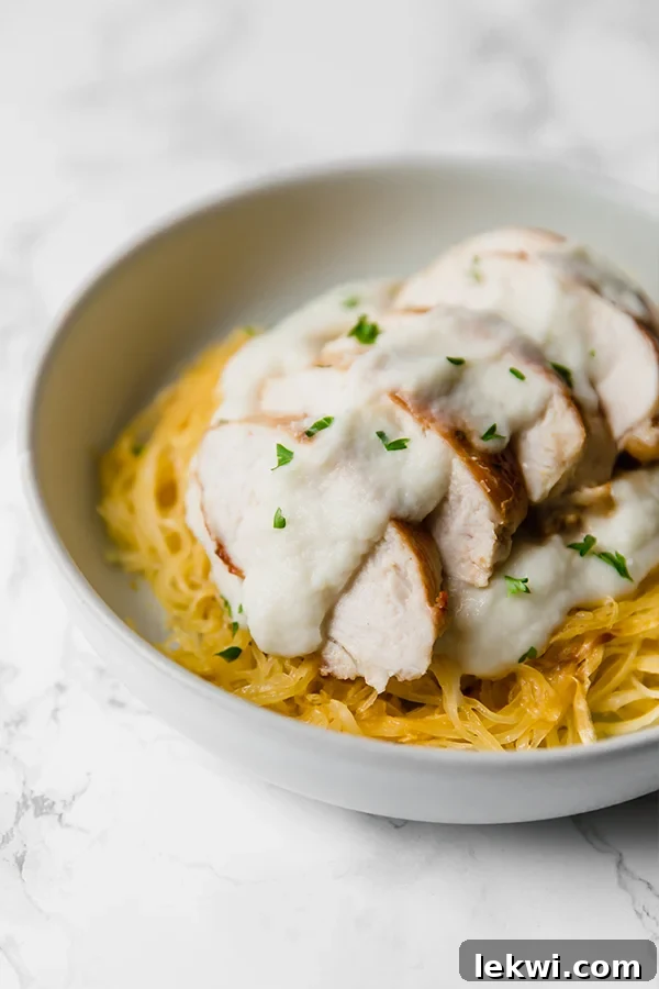 A white bowl showcasing the vibrant Paleo Spaghetti Squash Chicken Alfredo, garnished for a perfect meal.