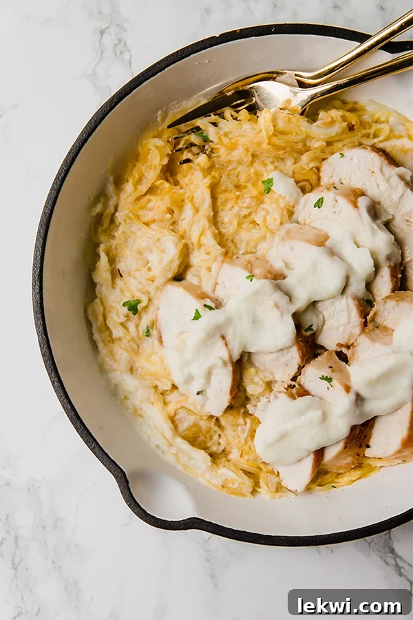 A warm Dutch oven filled with freshly cooked Paleo Spaghetti Squash Chicken Alfredo, ready to be served.