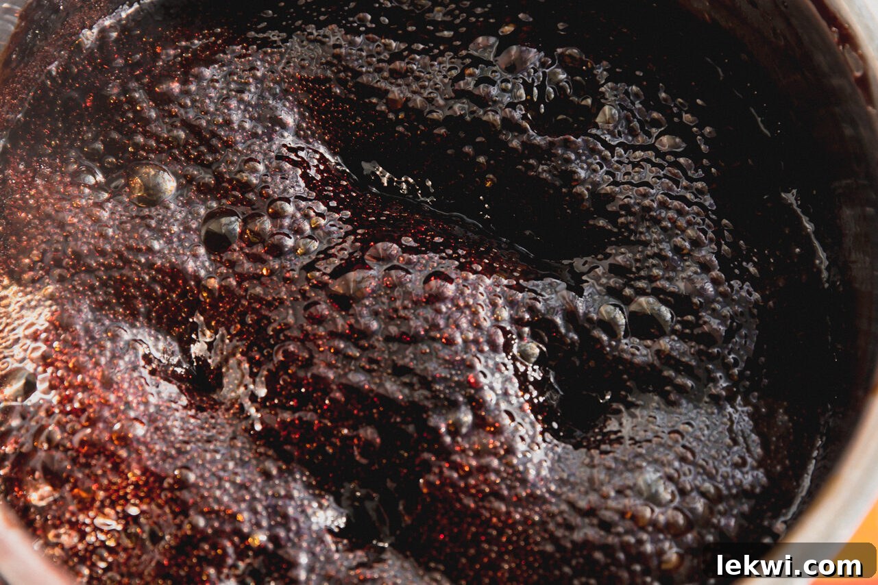 The elderberry and honey mixture bubbling and thickening in the pot, reaching the hard crack stage.
