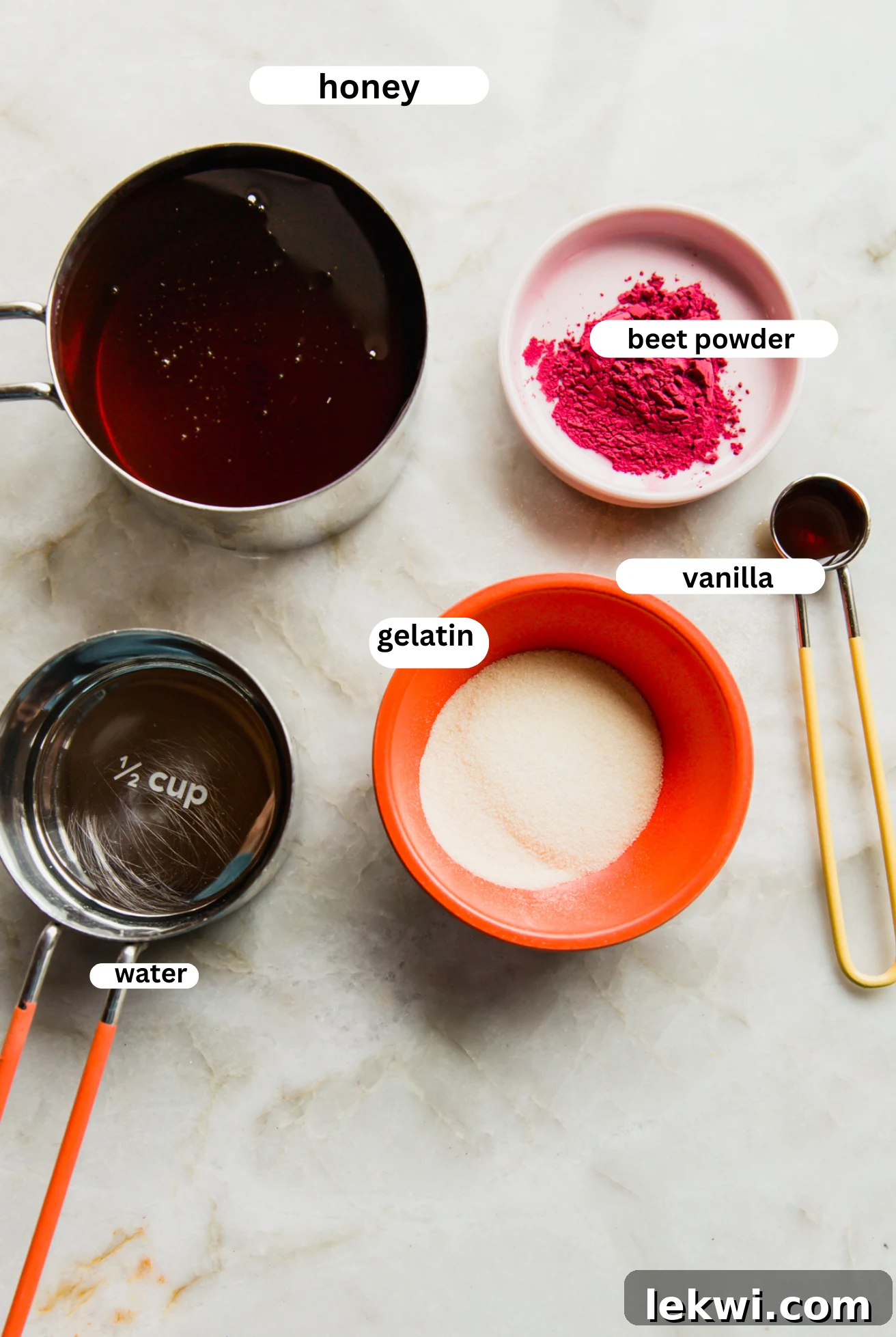 All the necessary ingredients for homemade pink marshmallows, including honey, beet powder, vanilla extract, and gelatin, neatly arranged in separate bowls, ready for preparation.