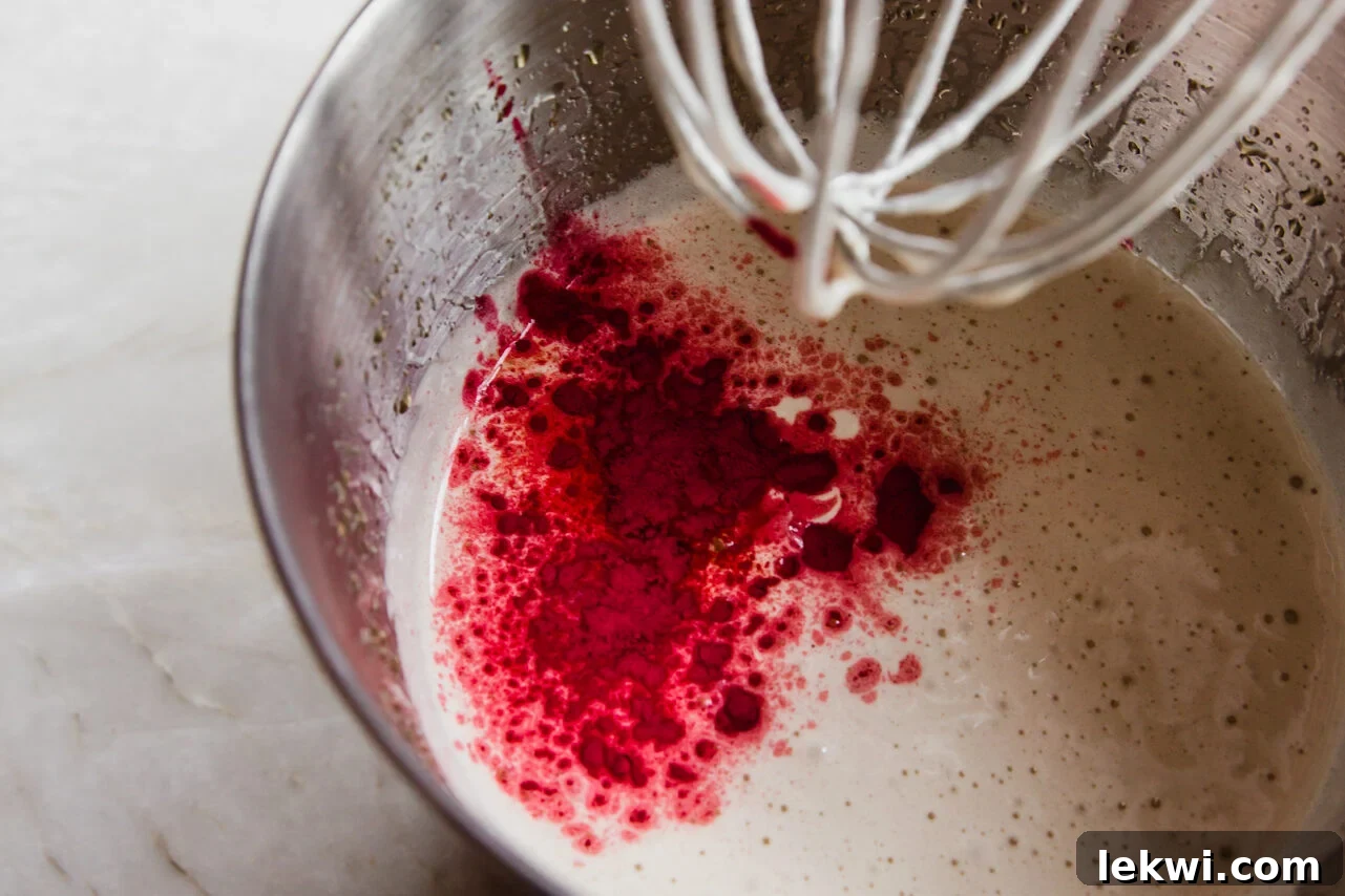 Marshmallow base mixture in a large mixing bowl, showing the consistency of honey, gelatin, and beet powder before whipping, indicating the initial preparation phase.