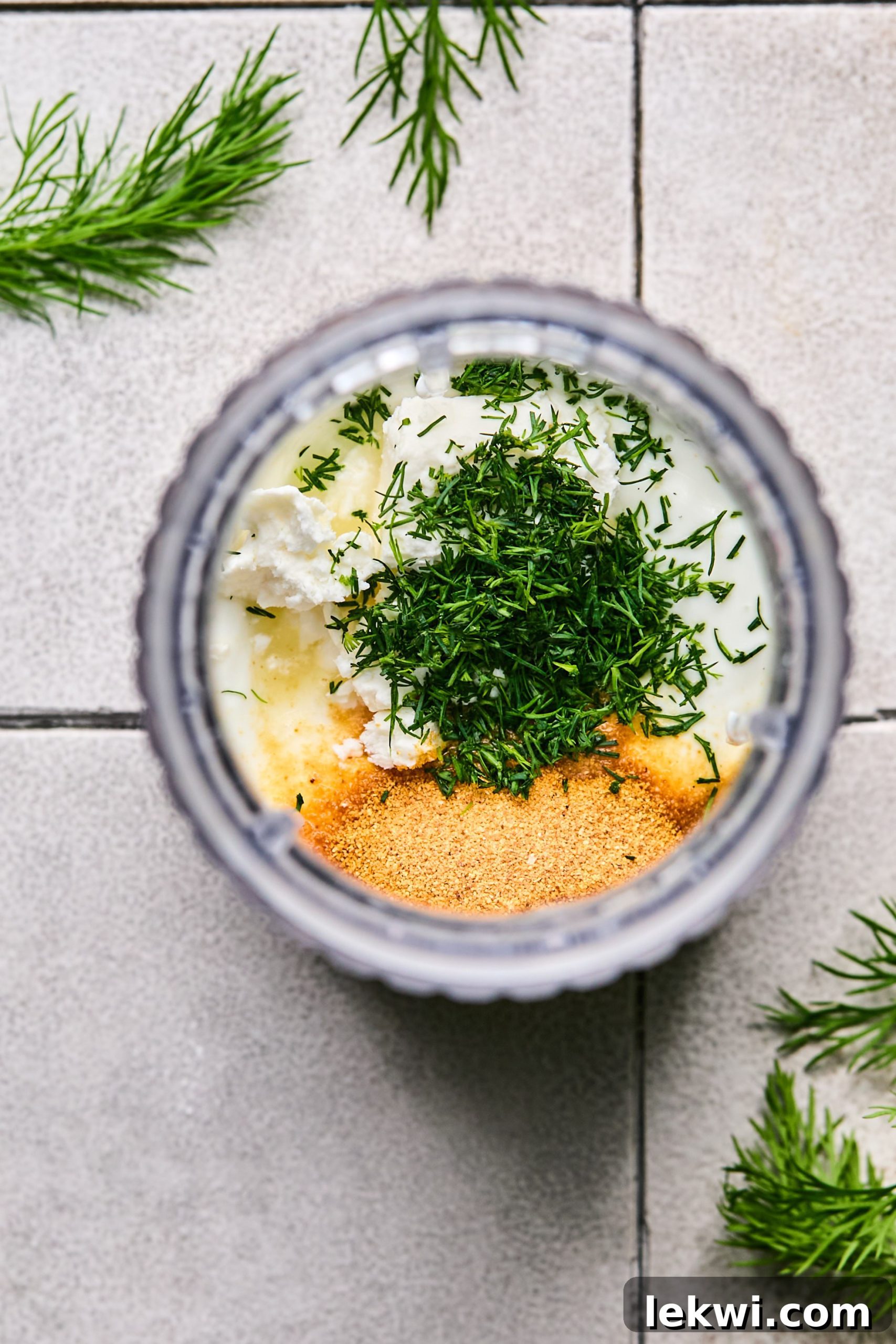 all ingredients for yogurt sauce in a tall mixing cup, ready to be blended