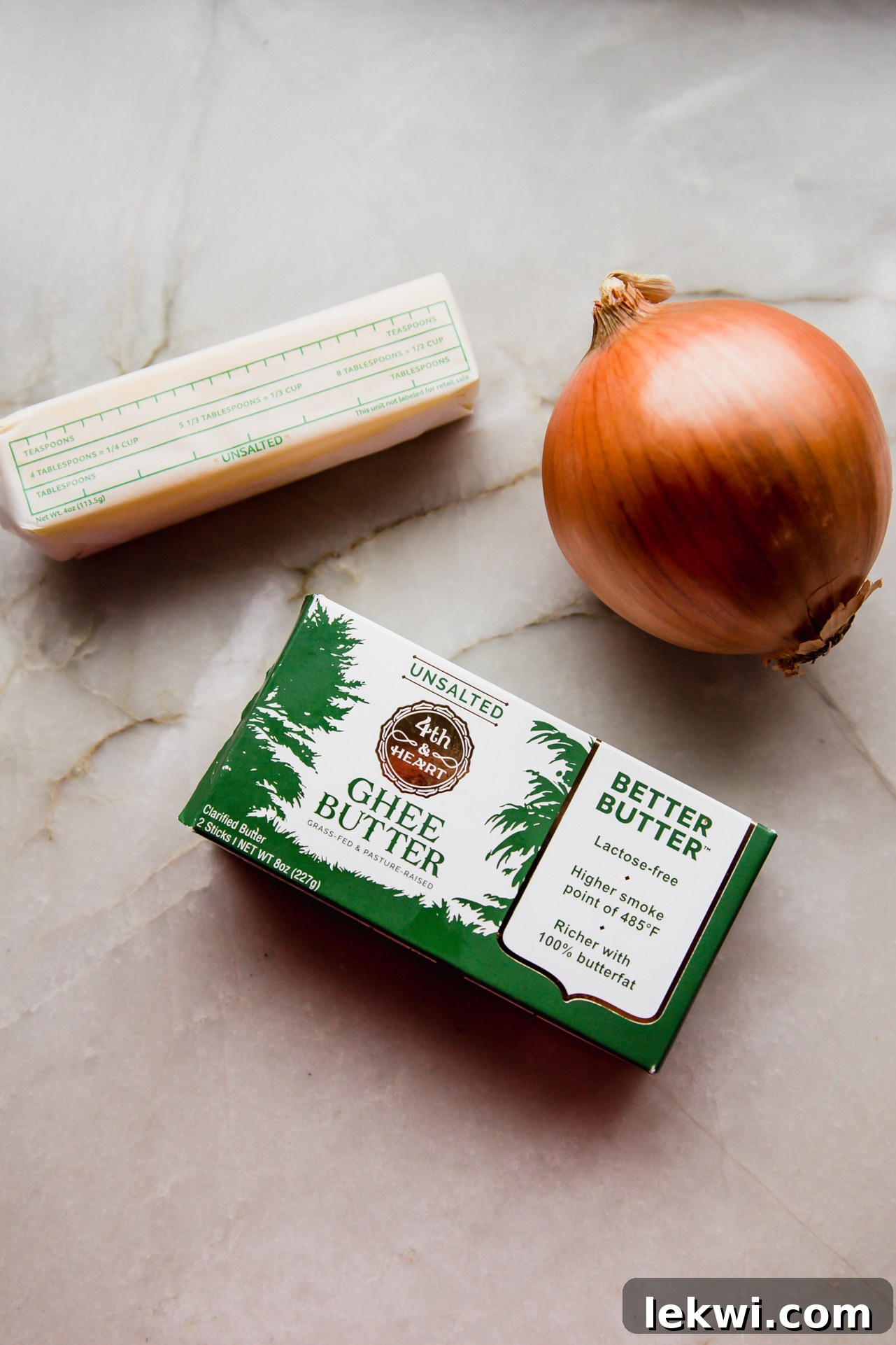 Close-up of ghee sticks and fresh yellow onions, ready for caramelization, highlighting key burger ingredients.