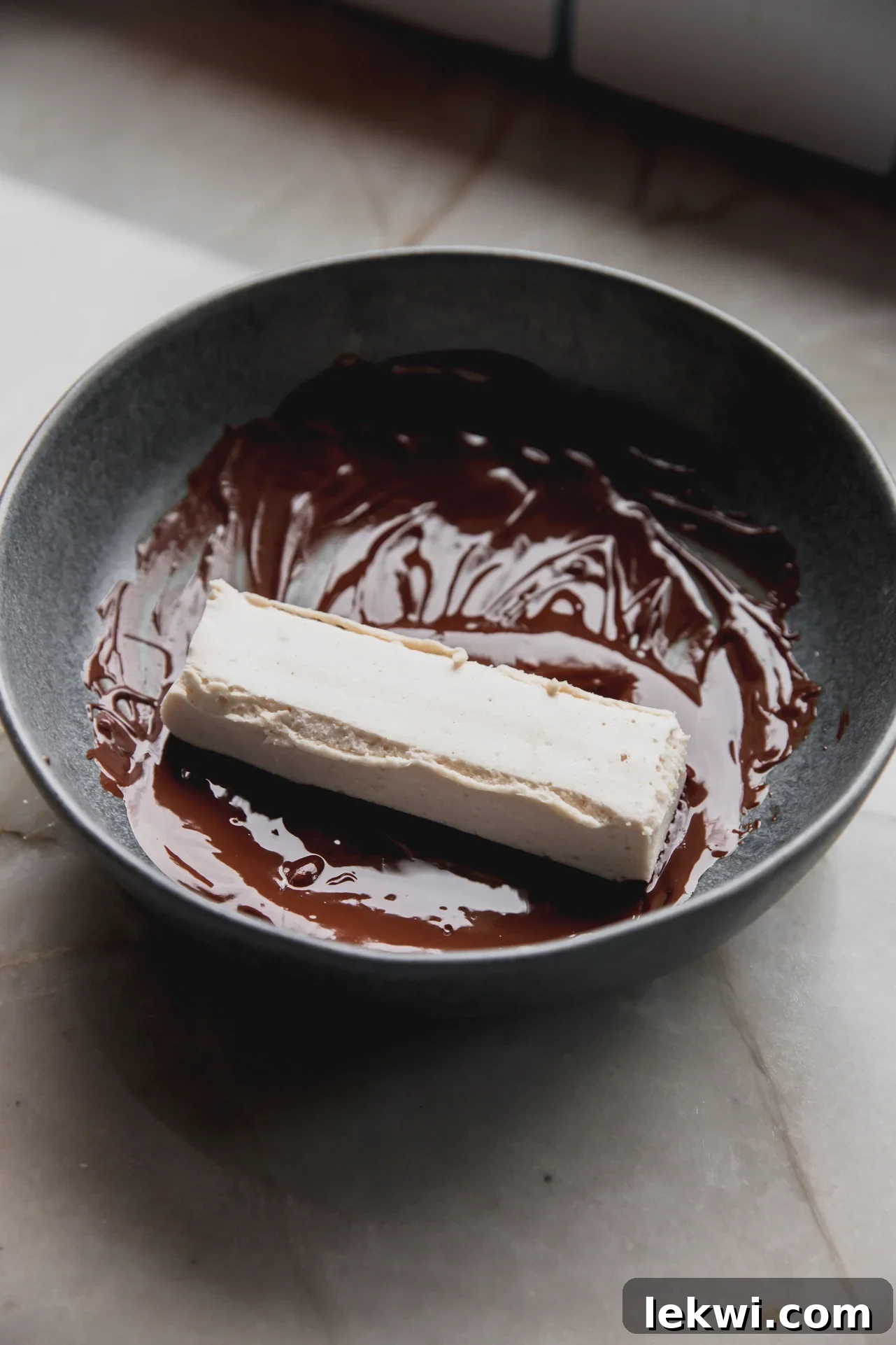 marshmallow protein bar being dipped in melted chocolate