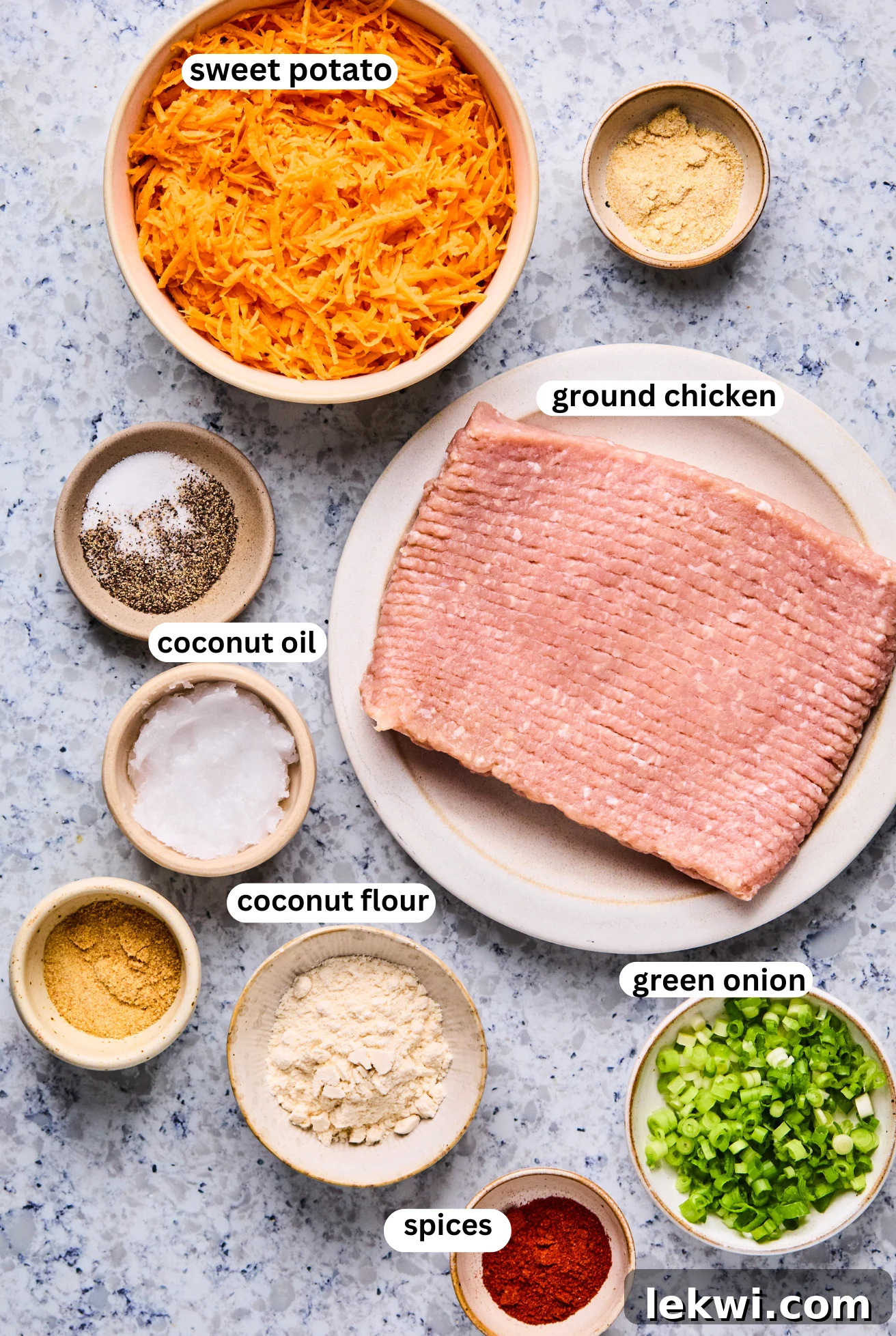 Close-up of the Sweet Potato Chicken Popper ingredients laid out on a kitchen counter, including ground chicken, shredded sweet potato, coconut flour, and seasonings, ready for mixing.