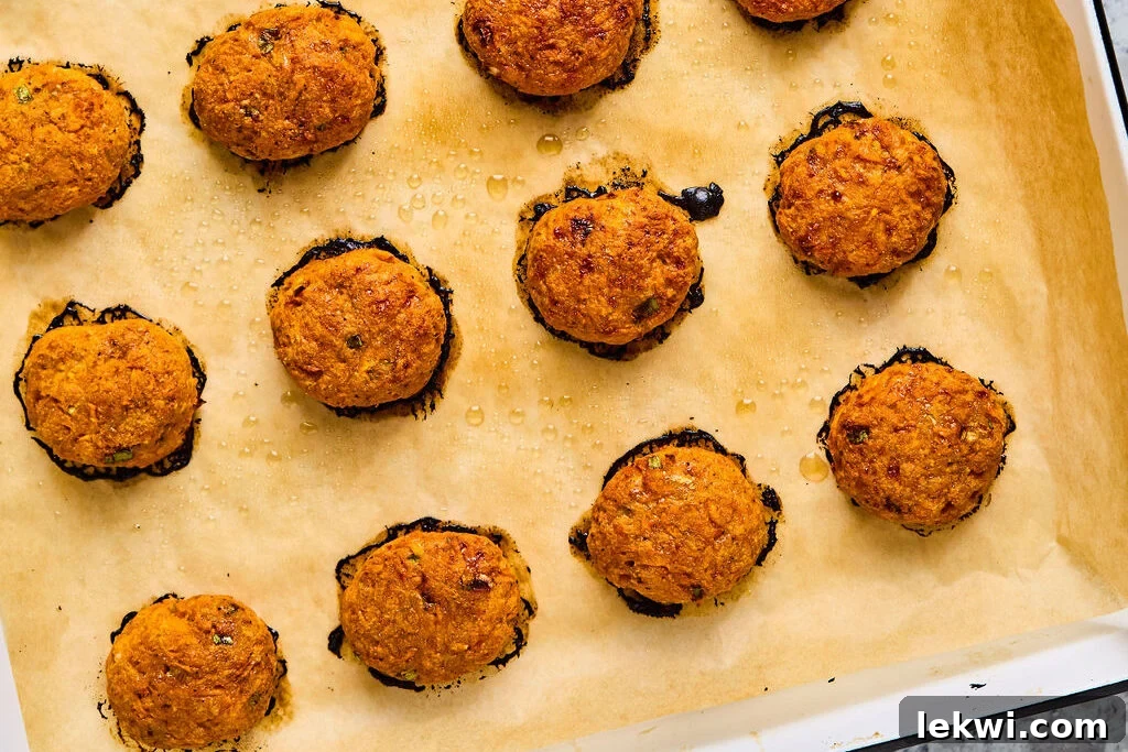 Golden-brown, perfectly cooked sweet potato chicken poppers are displayed on a baking sheet, freshly removed from the oven and ready to be served.