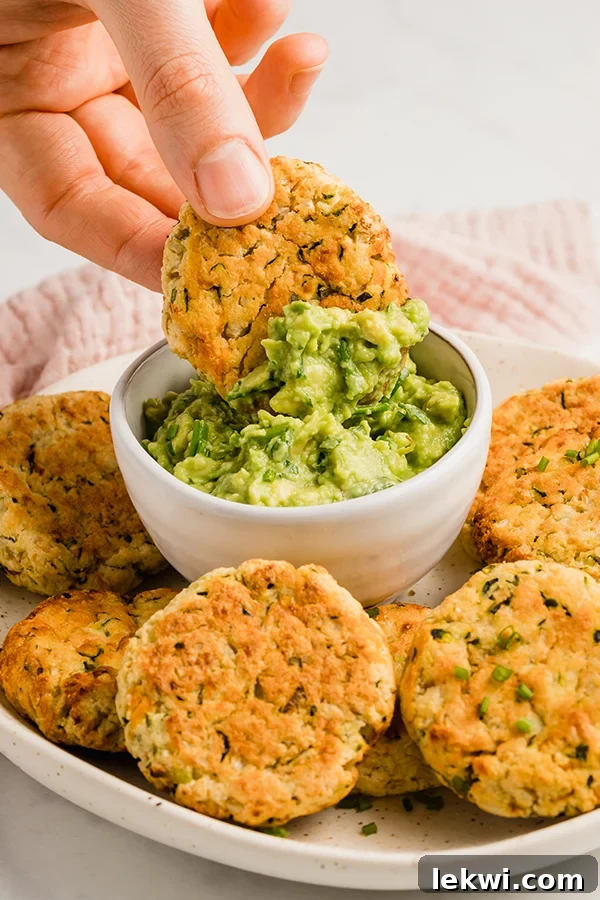 baked veggie nuggets on a plate with one being dipped into guacamole
