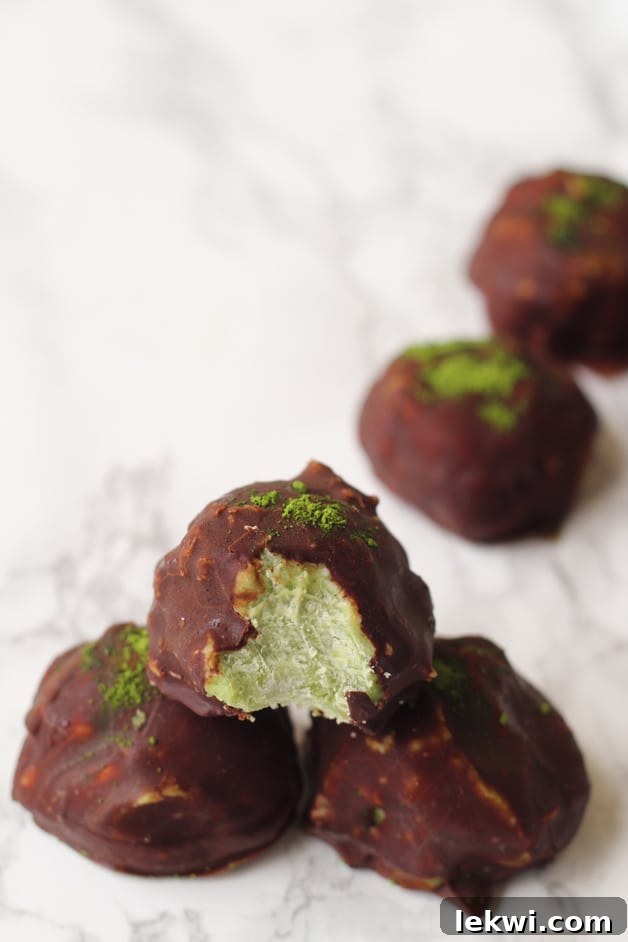 A row of chocolate matcha energy balls stacked on a platter.