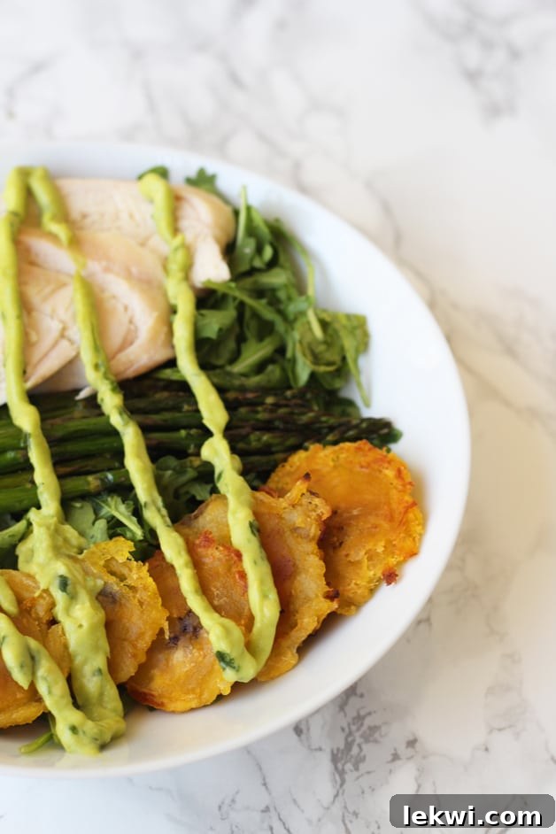 Nourishing Chicken, Asparagus, and Plantain Breakfast Bowl 2 A vibrant, balanced breakfast bowl featuring fried plantains, seasoned chicken, crisp asparagus, fresh greens, and a creamy avocado dressing.