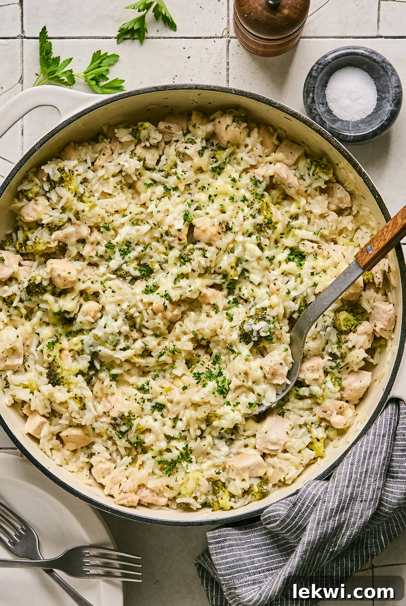 One pot broccoli cheddar chicken and rice served in a large cast iron pot, fully cooked and garnished.