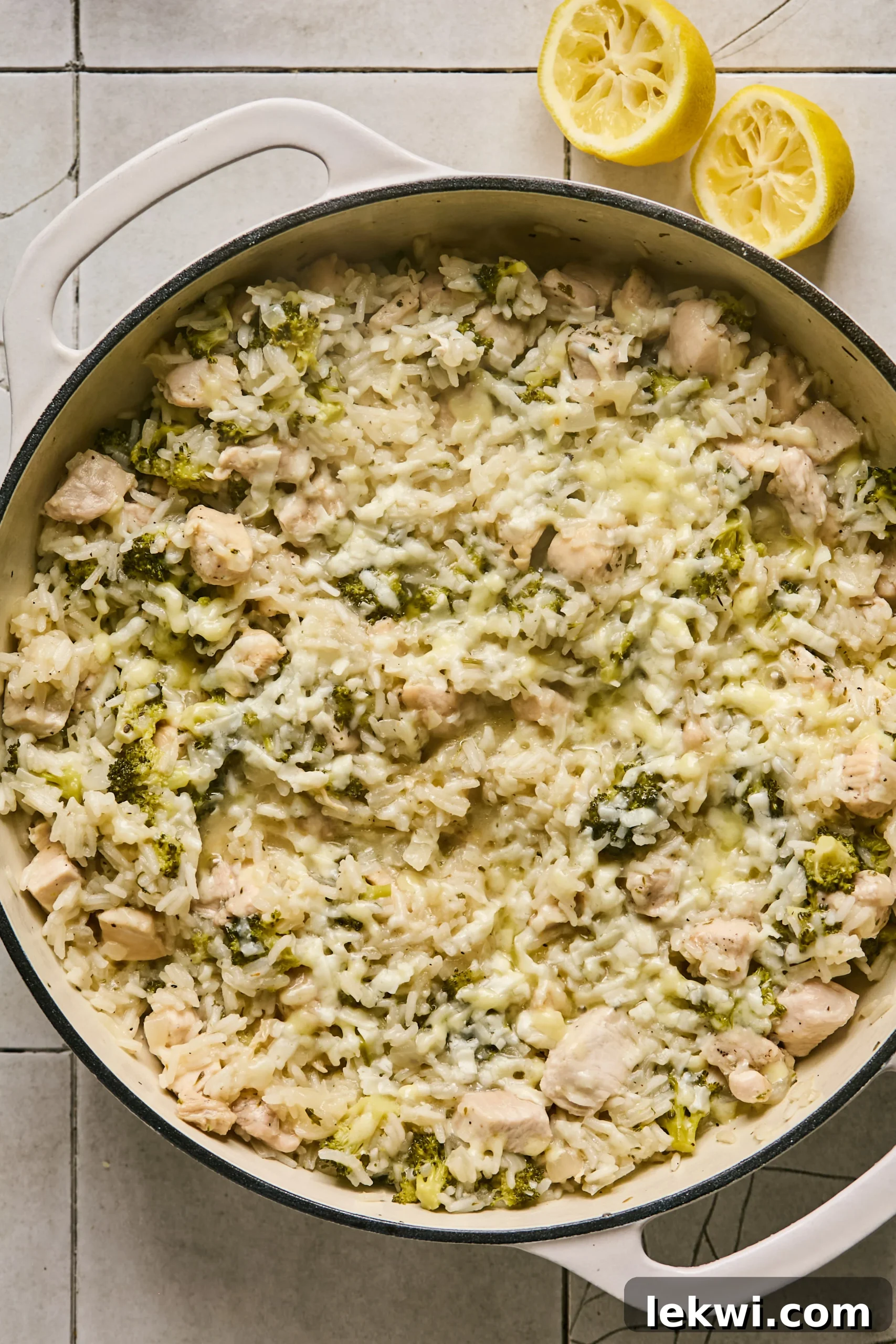 The finished One-Pot Broccoli Cheddar Chicken and Rice, topped with melted cheese and fresh chopped parsley, served in the cast iron pan.