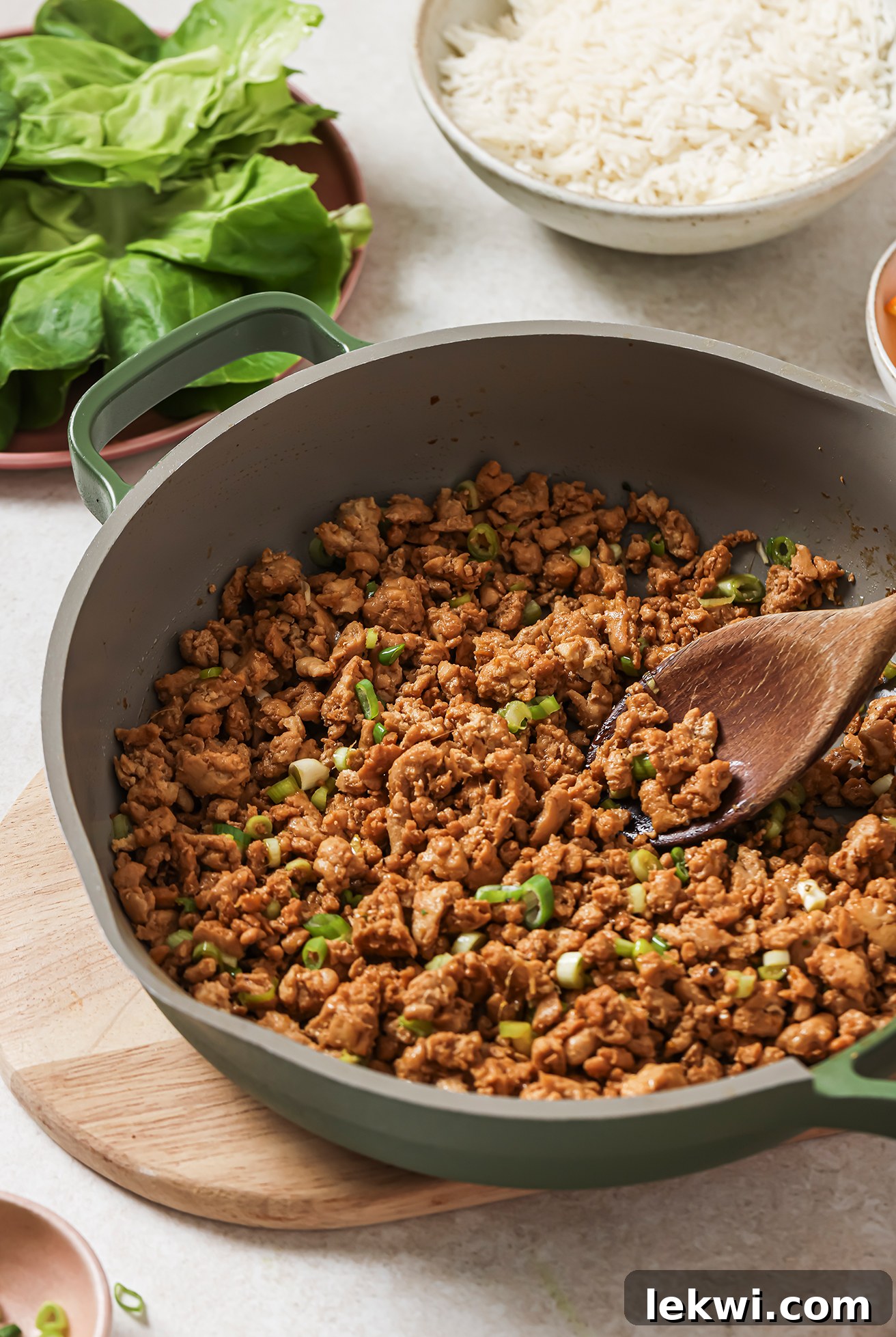 A pan of orange ground chicken, ready to be made into orange ground chicken lettuce cups.