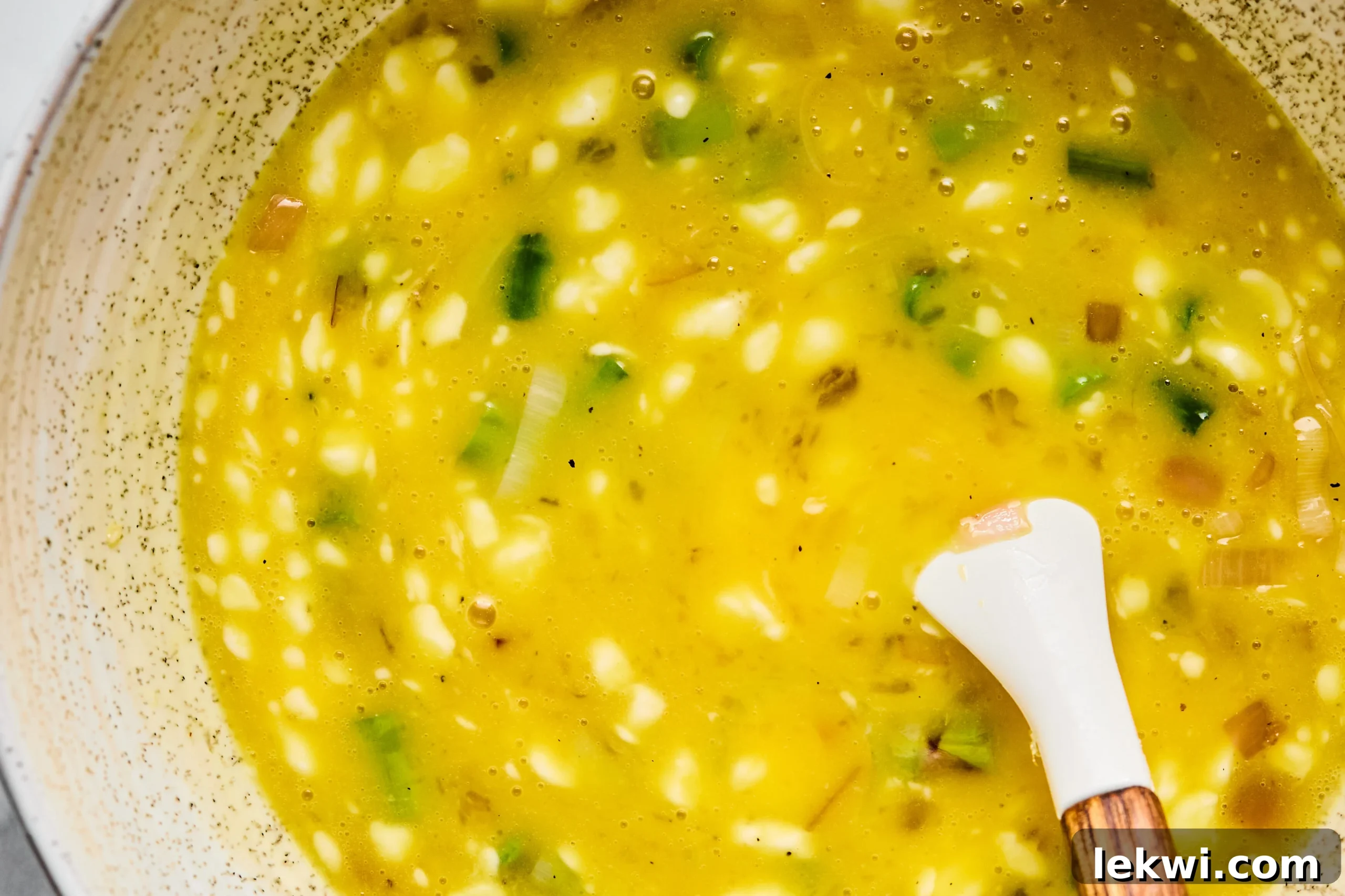 Egg mixture in a bowl, before adding the cooked vegetables to the quiche.