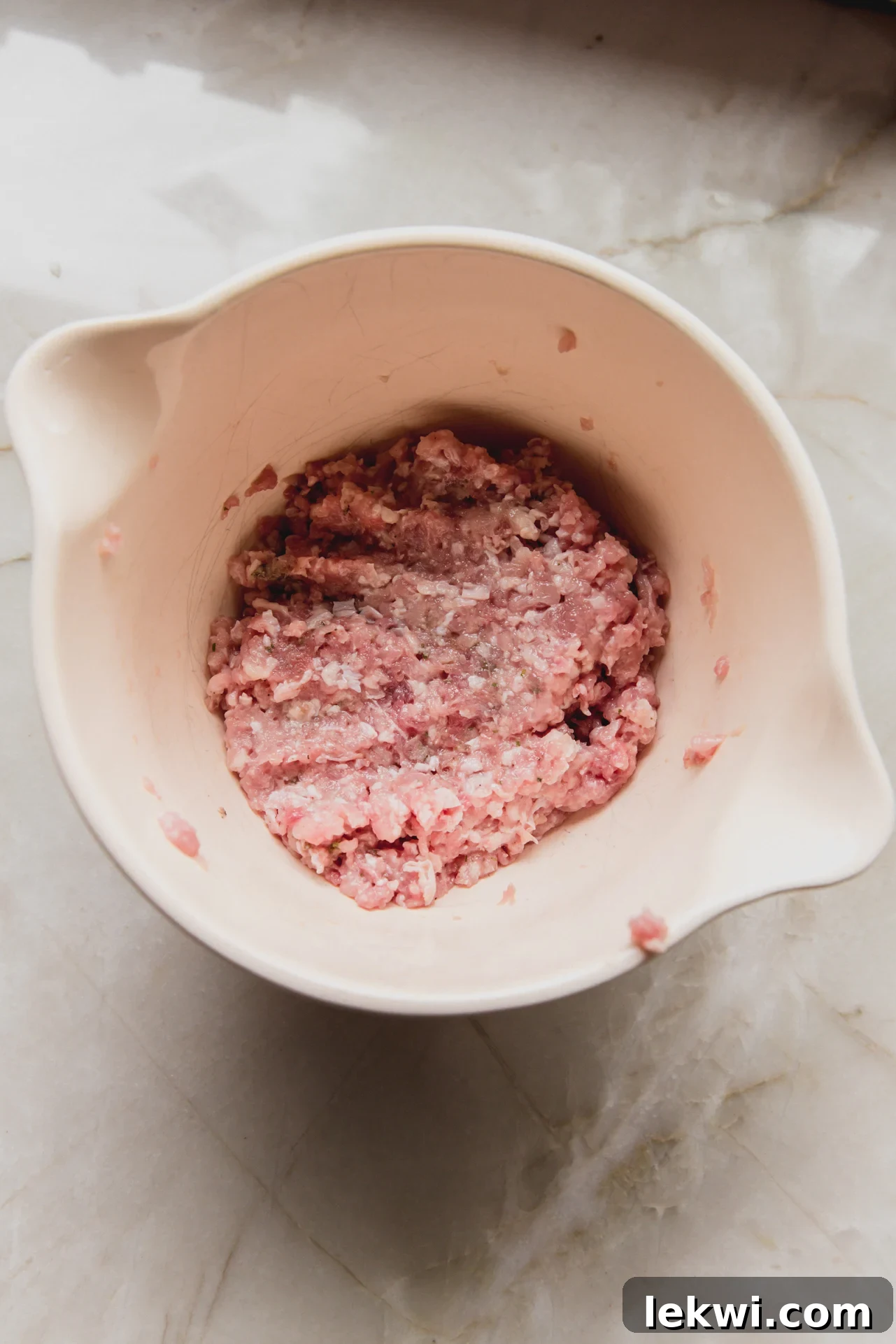 A bowl filled with seasoned ground chicken mixture, ready to be spread onto tortillas.