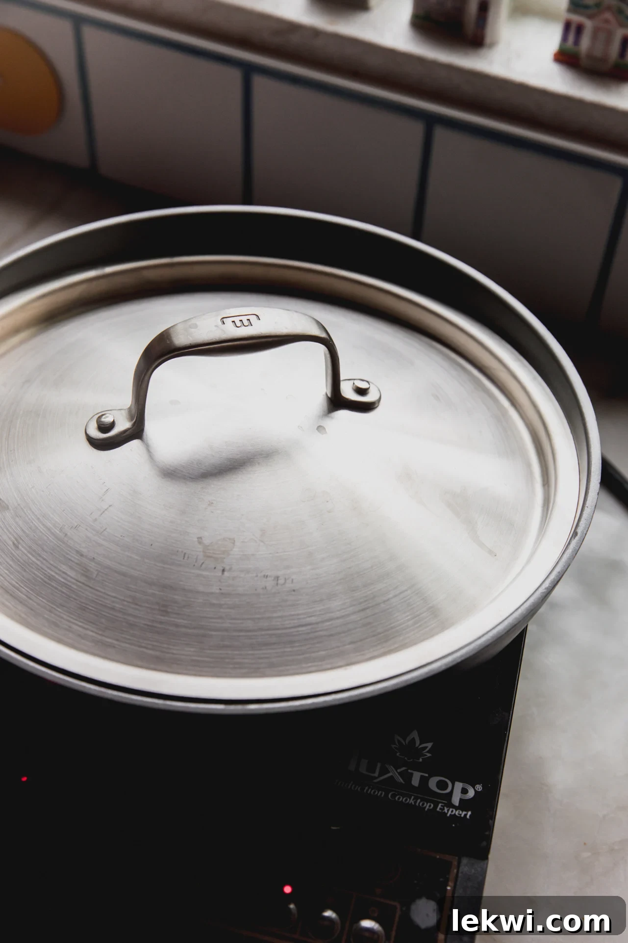 The chicken parm smash burger taco in the pan, covered with a lid to steam and perfectly melt the cheese.