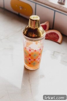 A cocktail shaker with its lid securely on, being vigorously shaken to combine the mocktail ingredients.