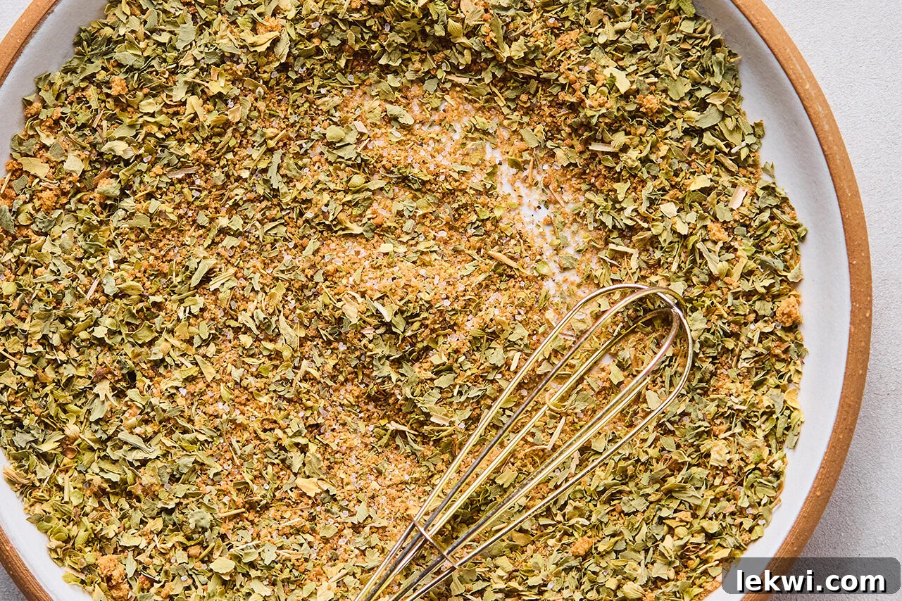 Pork shoulder spice rub in a bowl with a whisk.